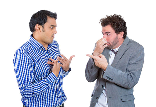 man pointing at another man while holding nose to blame him for bad breath